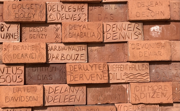 Terracotta tile featuring the name Deane among other tiles with surnames also starting with the letter D on the Wall of Names, Golden Square Freedom Park, Bridgetown, Barbados. Photo by LM Deane